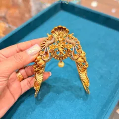 This antique-finish bajuband has a unique design with a Nagas (serpent) hood protecting the central deity motif. The single pearl drop adds a touch of elegance to this traditional armlet.