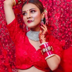 A bride in a vibrant red outfit, wearing a modern, wide diamond choker. This shows how you can pair contemporary jewellery with traditional colors for a unique look.
