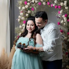 Holding onto the promise of the future. This couple's portrait uses the simple prop of baby shoes to tell a powerful story of love and anticipation in a beautifully styled studio setting.