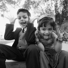 The kids are always the life of the party. This black and white photo of two children making funny faces for the camera is a perfect example of the genuine, fun moments we love to capture.