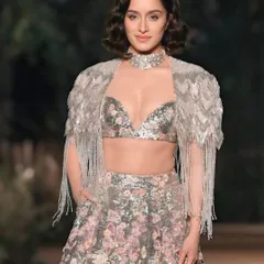 The stunning Shraddha Kapoor gracing the runway. This portrait captures her elegance and the intricate, sparkling details of her designer lehenga.