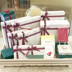This hamper is filled with beautifully wrapped gift boxes in a white marble and burgundy theme, ready to delight any recipient.