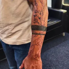 A full forearm sleeve depicting a lightning storm. This abstract piece uses bold black bands and chaotic lines to capture the raw power of nature.