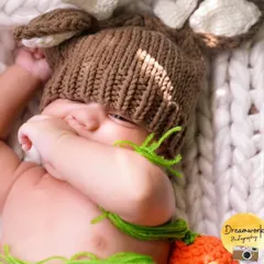 A shy little bunny. We provide a variety of cute and cozy props, like this knitted bunny hat, to add a touch of whimsy to your newborn's first photoshoot.