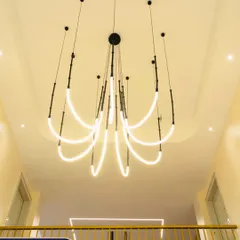 For this modern home in Guwahati, I designed a dynamic, sculptural LED chandelier to cascade through the double-height space above the staircase. It's not just a light fixture; it's an architectural statement that draws the eye upward and fills the home with a contemporary, artistic energy.