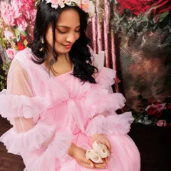 It’s the little details that hold so much meaning. Here, an expecting mother in a soft pink gown holds a tiny pair of baby shoes, a sweet symbol of the little one on the way. I love incorporating personal or symbolic props to make your maternity photos even more special.
