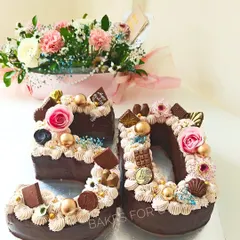 Fabulous at 50! This unique number cake is shaped into the number "50" and lavishly decorated with chocolates, fresh roses, and gold accents. It's a stylish and delicious way to celebrate a big milestone.