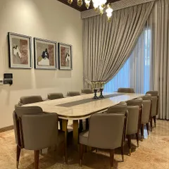 This angle highlights the custom artwork and the elegant sweep of the curtains, which add softness and a personal touch to the formal dining space.
