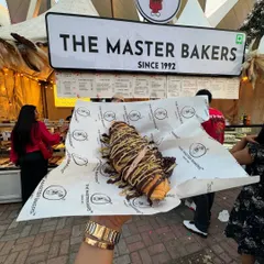 Our Kunafa Croissant, seen here at the Horn OK Please festival, is a star. Held up against the backdrop of our bustling stall, you can see the generous layers of chocolate and pistachio that make it so irresistible.