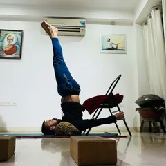 Using a chair for support in Salamba Sarvangasana (Supported Shoulderstand) helps maintain alignment and reduces pressure on the neck. This makes the "queen of asanas" safer and more restorative.