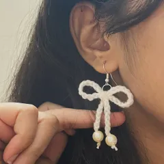These delicate white bow earrings with pearl drops are elegant and sweet. They are perfect for a soft, feminine look.