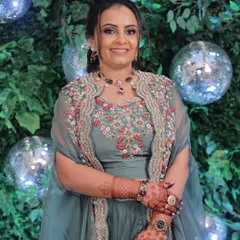 Soft glam with warm coral hues for an engagement party. This look features a defined smokey eye and a simple twisted hairstyle, set against a fun disco ball backdrop.