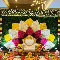 I can create grand, artistic floral backdrops for any occasion. This large lotus design, made entirely of fresh flowers in vibrant colors, provides a stunning and memorable stage for a Seemantham or engagement ceremony.