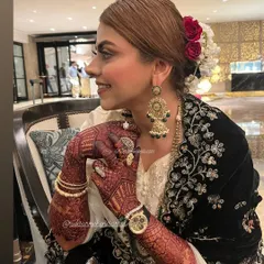 A happy bride is the best reward for my mehnat. Here you can see the rich, dark stain of the bridal mehndi a day after application, which is exactly what we aim for. The intricate design on her hands beautifully complements her entire look.