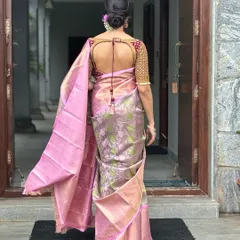 A back view of a client in a pink and green Kanchivaram saree, showing the beautiful cut-out design of her maroon brocade blouse.