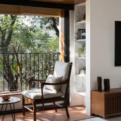 We create intimate moments within a home, like this quiet seating area for two. By perfectly framing the lush greenery outside, we turn a simple window into a private retreat, blending the interior with nature.