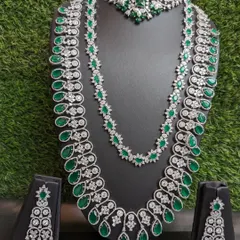 For a truly glamorous reception look, I recommend this two-layered American Diamond haara with emeralds. Paired with its matching choker and earrings, it creates a look of pure opulence.