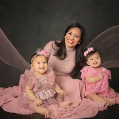 Double the giggles and double the love with these beautiful twin sisters. This portrait with their mommy shows the pure happiness of their family, captured with a flowing fabric backdrop for an artistic touch.