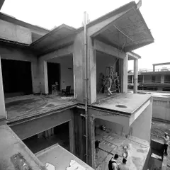 An on-site shot of a 15,000 sq. ft. architectural project taking shape. This view from above shows the complex interplay of levels and volumes, highlighting the strong geometry and clean lines that define the home's structure even in its early stages.