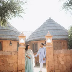 Saloni and Kanav at the entrance of the Khimsar Dunes Village. The unique, rustic architecture of the huts provides a wonderful backdrop for a desert-themed shoot.