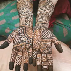 A classic full-hand mehendi with filled fingertips, a popular choice for a traditional look. The design features a dense mix of jaali patterns and delicate swirls.