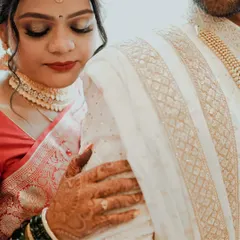 A detail-oriented shot focusing on the bride's henna-adorned hand on the groom's sherwani. This captures the texture, tradition, and tenderness of the moment.
