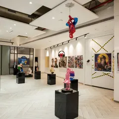 This angle highlights the playful and unexpected nature of our curation, with a Spider-Man sculpture suspended from the ceiling. It demonstrates how we use the entire volume of a space to create a dynamic and engaging pop art experience.
