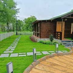 The finished farmhouse garden, featuring a lush lawn that meets a custom stone pathway. The white picket fence and modern path lighting complete the clean, rustic look.
