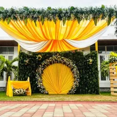 For this outdoor naming ceremony, I designed a vibrant and sunny theme. The setup features a grand arch of greenery, a backdrop of draped yellow and white fabric, and a central floral medallion, creating a beautiful focal point on the lawn.