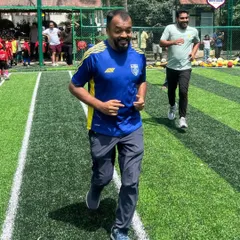 An adult participant jogging on the field during our Community Fest. These events are a great way for everyone to get active and enjoy the game in a relaxed, fun setting.