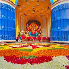 A low-angle view of the Ganesh Chaturthi pandal, highlighting the grand scale of the flower rangoli and the detailed fabric work on the ceiling. This perspective shows the immersive environment we create for festive events.