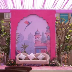 Another seating area with a custom-printed backdrop depicting a whimsical palace scene. The blush-colored sofa and soft cushions provided a perfect spot for photos.