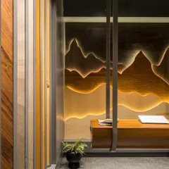 A custom-designed swing bench, suspended from the ceiling, sits before a backlit veneer wall art piece. This feature creates a memorable and interactive moment within the showroom.