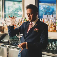 A portrait of a bartender in action, pouring a classic cocktail. Capturing the human element behind the bar adds authenticity and tells the story of the establishment.
