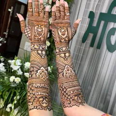 A beautiful, full-coverage design with repeating floral and peacock motifs. The patterns flow seamlessly from the fingers to the elbows, creating an elegant and traditional bridal mehendi.