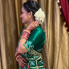 A side profile of a wedding guest looking elegant and ready for the event. I styled her hair in a classic bun and adorned it with a fresh white gajra for a timeless, traditional touch.