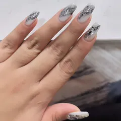 Another view of the shattered silver foil nails, showing the dynamic and reflective texture on long, square-shaped extensions.