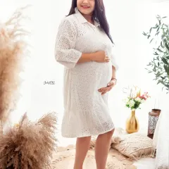 A casual white dress can be just as stunning for a maternity shoot. This candid shot captures a moment of pure joy, with the soft, bright light of my boho corner creating a dreamy feel.
