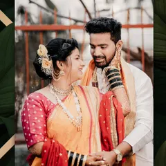 A candid moment of love and laughter. The bride looks lovingly at her groom, her smile radiant in her traditional orange and red Nauwari saree.