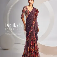The Delilah Saree Set in a deep plum hue. This ensemble features a printed ruffle saree with embellishments, matched with a sweetheart neck printed blouse for a romantic and festive appearance.