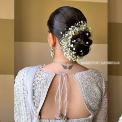 For this morning wedding, I created a neat bridal bun decorated with baby's breath, pearls, and unique triangular gold clips. This style is both traditional and modern, perfect for a bride with a distinct sense of style.