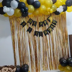 A shimmer curtain is a great way to create a simple photo backdrop. For this setup, I used a gold curtain with a "Happy Birthday" banner and a black, gold, and white balloon garland at the top.