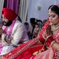 A beautiful, candid moment of the bride in prayer during her Anand Karaj. This close-up shot highlights her devotion and the solemnity of the ceremony, focusing on the personal and spiritual aspects of the day.