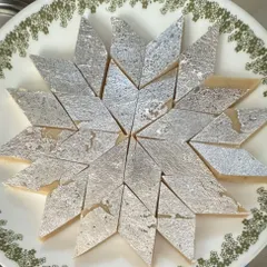 A fresh batch of our classic Kaju Katli, arranged in a beautiful star pattern. This iconic Indian sweet is made with premium cashews and just the right amount of sweetness, perfect for any celebration.