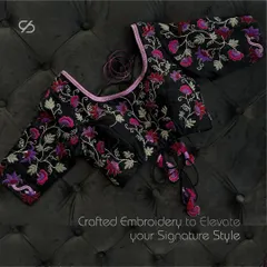 Intricate details, timeless appeal. This black designer blouse with vibrant floral embroidery defines luxury. The unique neckline and tassel ties are crafted to elevate your signature style.