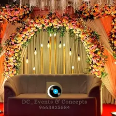 This Mehendi decor combines a dense floral arch with hanging Edison bulbs and warm uplighting, creating a cozy and stylish backdrop for the ceremony.