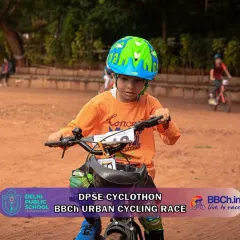 Pure determination on the face of a young champion. This rider, focused and driven, tackles the dirt track at our Urban Cycle Race, showing the grit of our junior competitors.