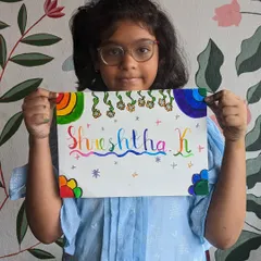 A young artist proudly holding up her colorful calligraphy nameplate, a beautiful piece of personalized art.