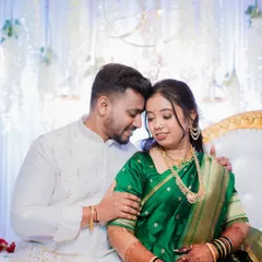 A classic Maharashtrian engagement portrait. The bride's beautiful green Paithani saree and traditional jewelry are complemented by the couple's gentle and happy connection, showcasing a moment of quiet celebration.