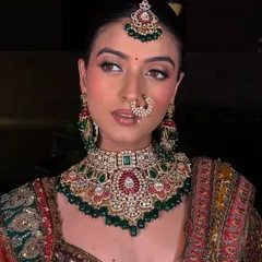 A close-up showcasing the flawless makeup and the stunning detail of the bridal choker. The combination of red, green, and pearl work makes this a versatile set for many traditional outfits.